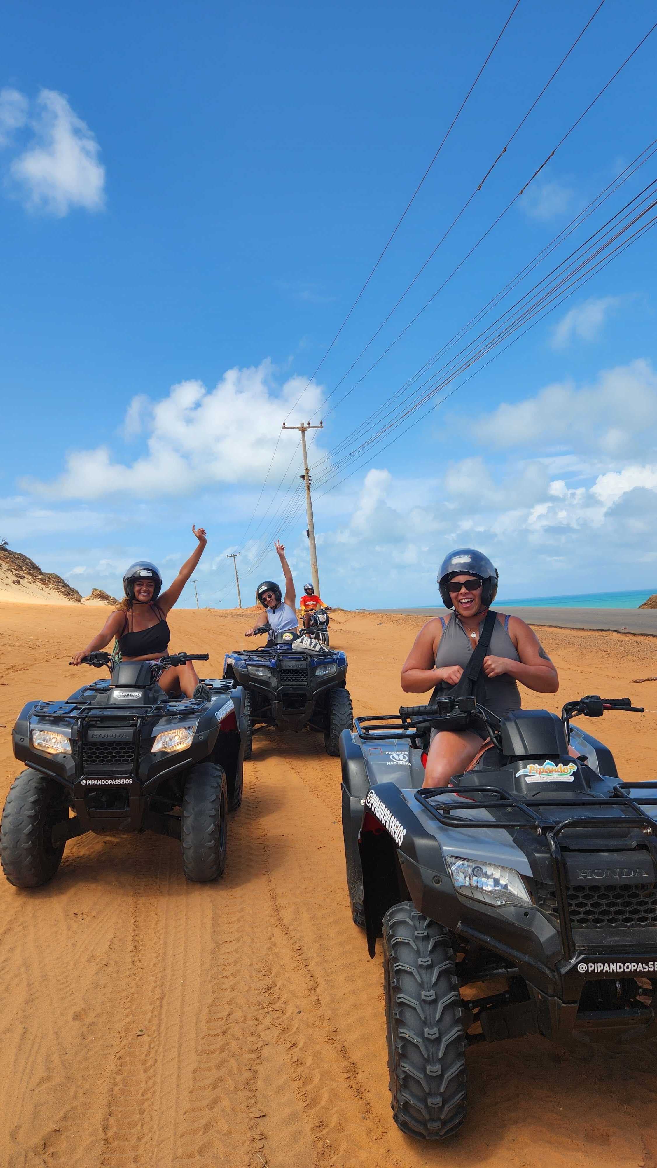 Community members on quad bikes across sand dunes
