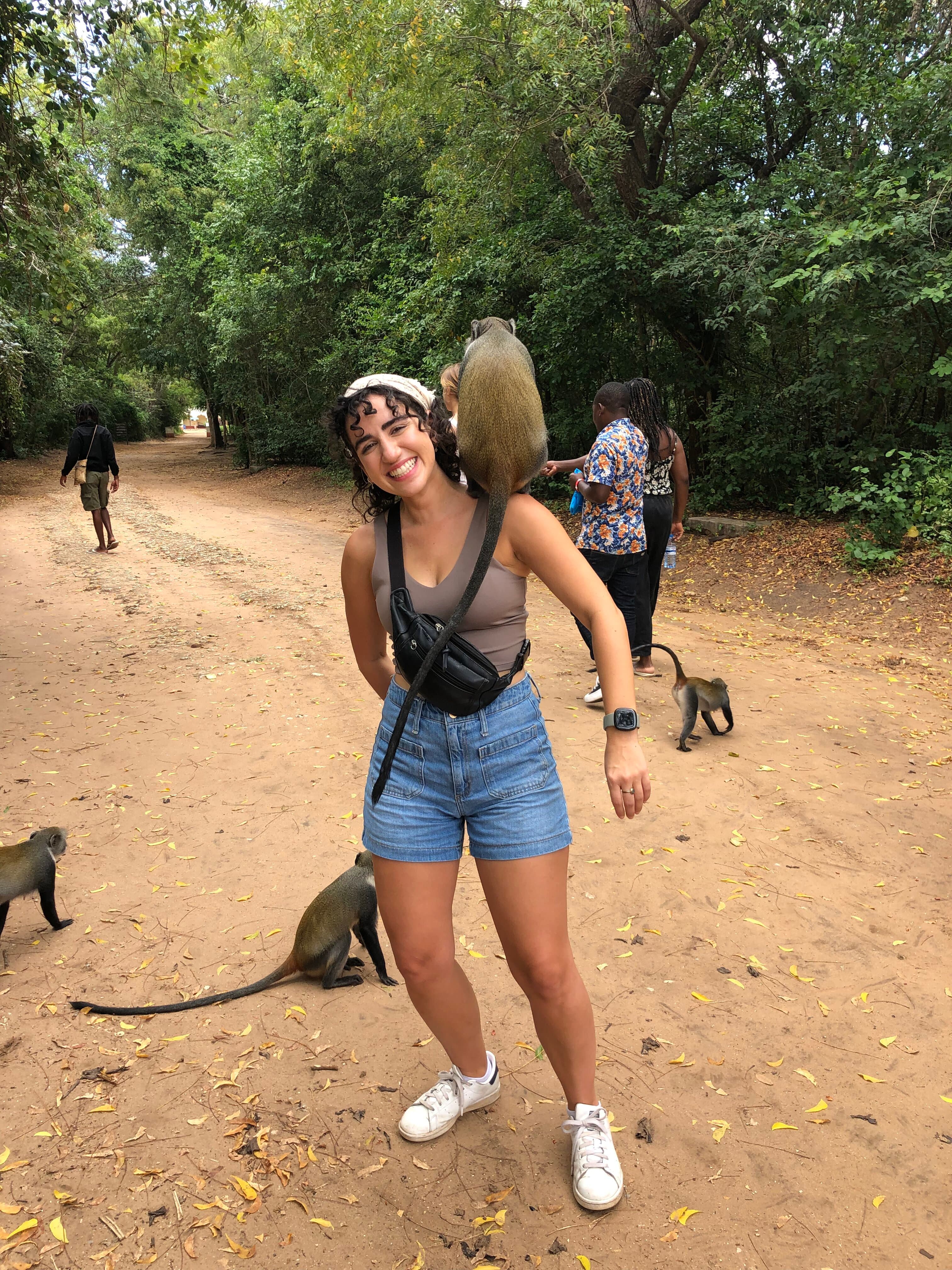 Community member smiling with a monkey on her shoulder