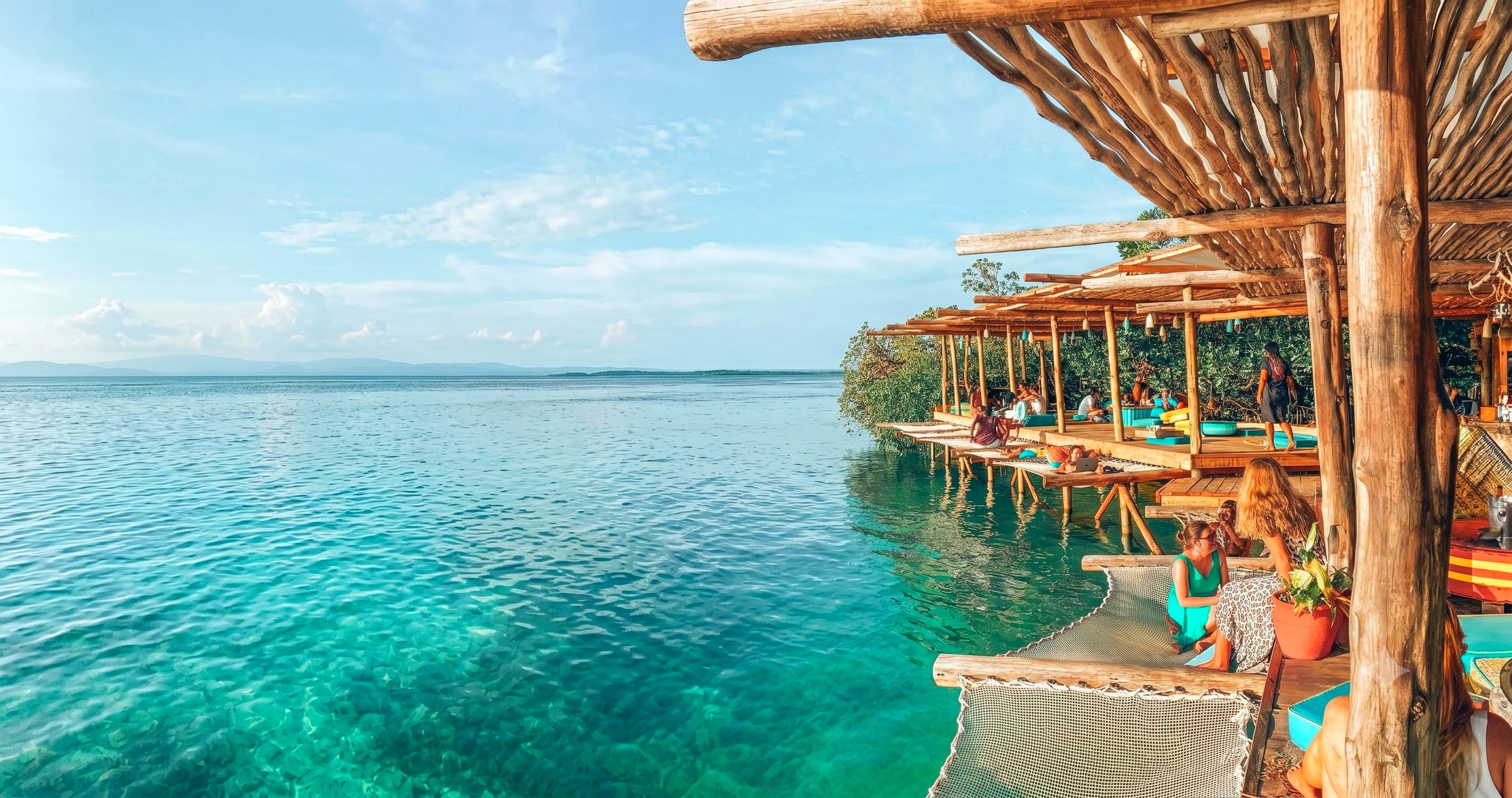 Noma Collective overwater bamboo lounge over turquoise water